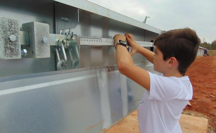 Middle schooler Seryn Singleton checks the scales at a poultry house in Hart County recently as part of the hands-on learning experience offered through FFA.