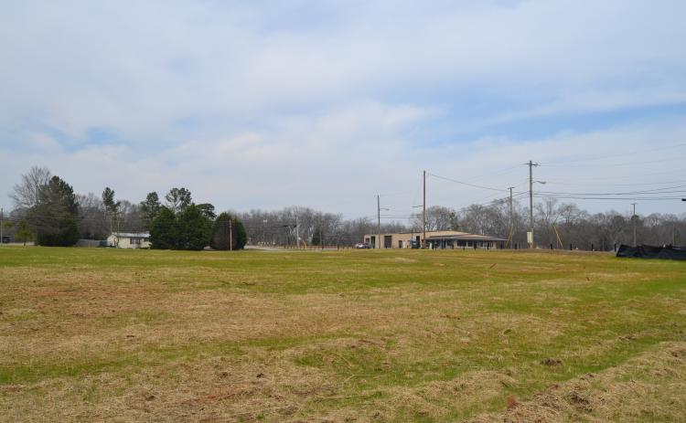Sunshot by Drew Dotson - The now empty lot at 55 Ridge Road is shown where a house once sat with the old Ed Murdock dealership in the background across the street.