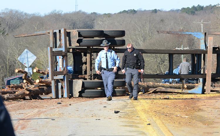 Sunshot by Michael Hall - Georgia State Troopers examine the scene of a log-truck crash on Thursday, March 4, that killed a Royston man.