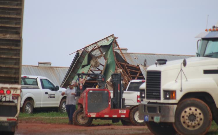 Sunshot by Grayson Williams - A pile of wood, metal and other materials shown is all that is left of a chicken house at a Woodland Way farm as workers clear the damage from a series of storms that swept through Hart County on March 25 and 26.