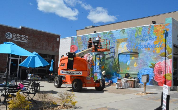 Color the World Bright, a organization of art students from the Lamar Dodd School of Art at the University of Georgia, add a splash of color to the wall of the Hart County Chamber of Commerce building with a new mural.