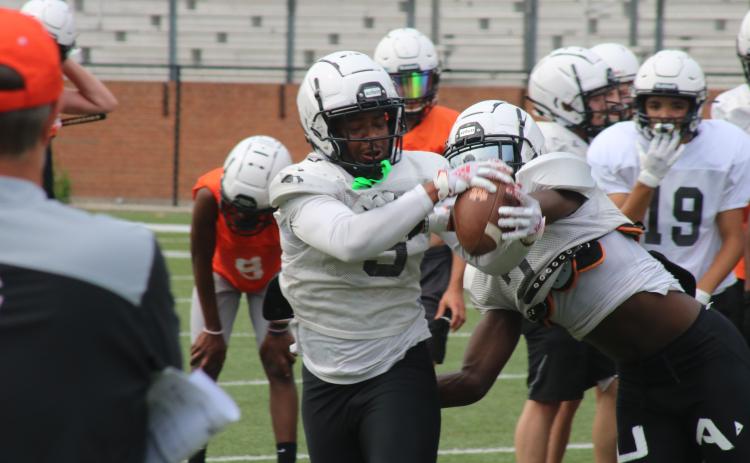 Sunshot by Grayson Williams Rising senior Malachi Kelley hauls in a pass and fights off a defender in a drill during the first day of spring practice at Herndon Stadium on Monday, May 17.
