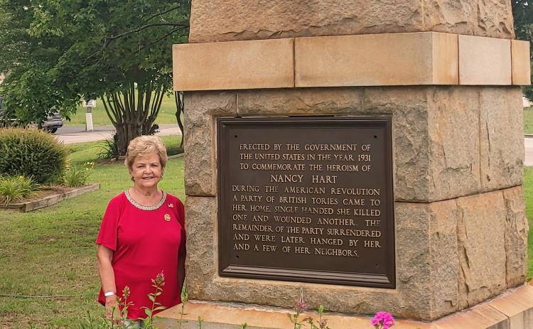 Dan Hunt/The Hartwell Sun Peggy Tucker poses next to the Nancy Hart monument near Old 29 Highway in Hartwell. Tucker helped to procure the monument and plant the adjacent garden.