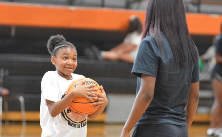 Dakota Wiley receives instruction from rising senior basketball player Kiyasia Montgomery.