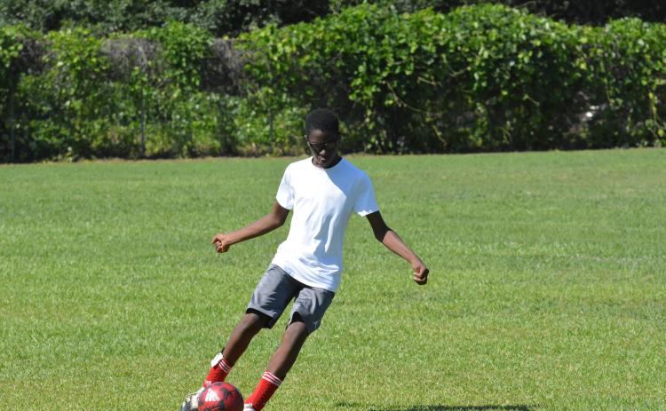 Naim Durham shoots for the goal at the YMCA soccer camp.