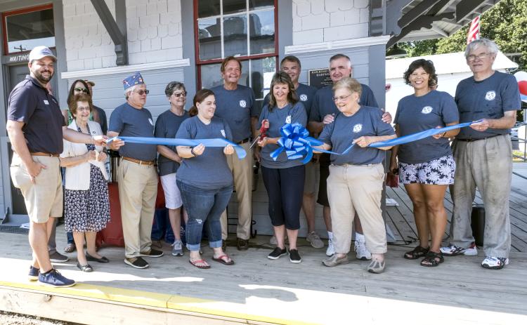 TORCH Board of Directors members cut the ribbon, marking the opening of the train depot and Railroad Street Park.