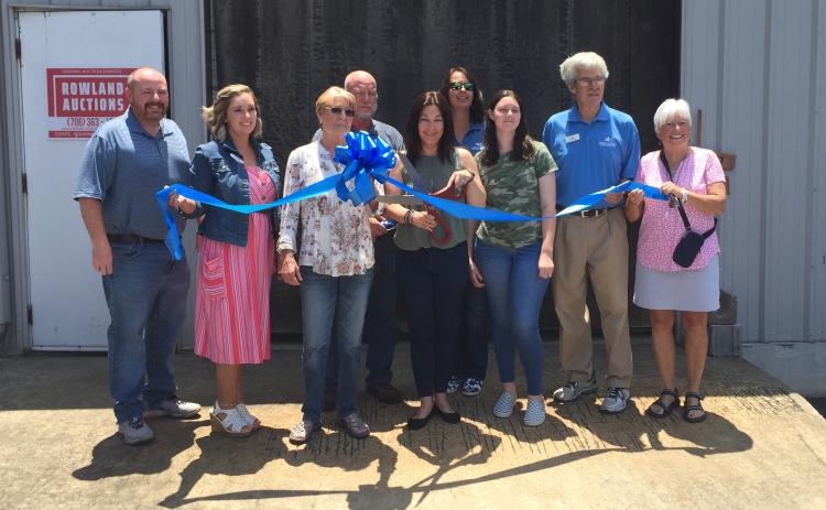Josh Brannen/The Hartwell Sun - Hartwell Main Street and Hart County Chamber of Commerce members join Angie Rowland (scissors) for Rowland Auctions’ ribbon cutting.