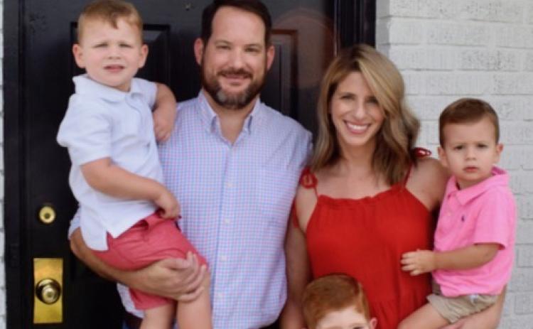 Dan Leard, wife Collen and their kids smile in front of their home.