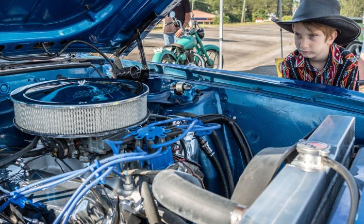Wyatt Smith (8) admiring the engine of a 1969 Mach 1 Mustang.