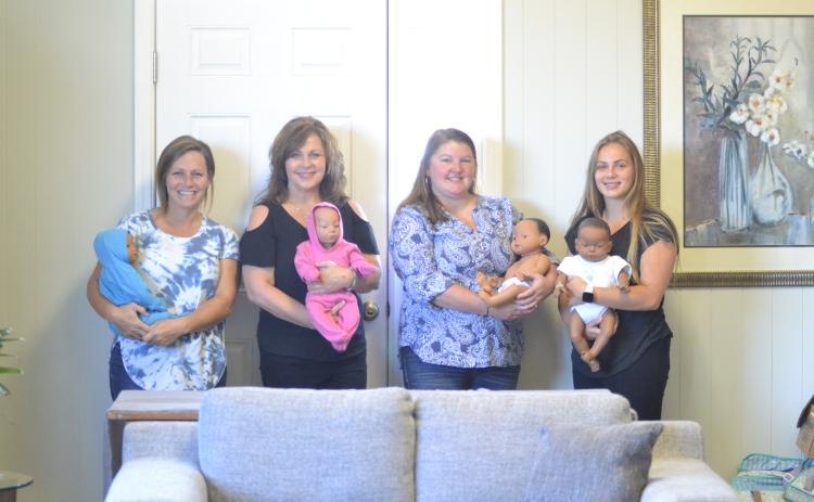 From left to right, Mindy Wise, Tammy Fyre, Barbara Stowe and Claire Beggs display the new dolls at Hart Life will be used as part of the Earn While You Learn program.