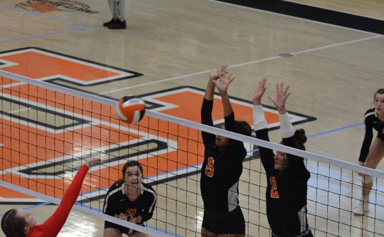 Alexis Walker (9) and Lille Kate Rogers (2) block the Madison attack as Aliza Hart (3) waits to make a play.