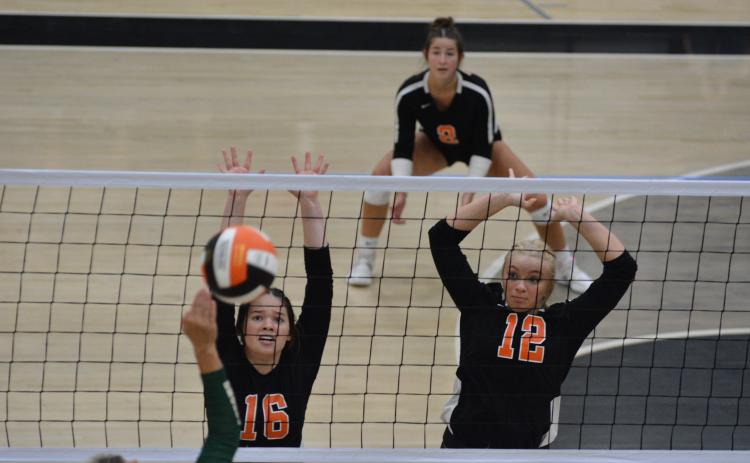 Caitlyn Key (16) and Cali Beebe (12) go up to block the attack.