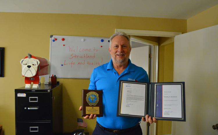 Tim Strickland proudly displays his award for 31 years of service and his award for driving a million miles or 30 yea without a preventable accident.