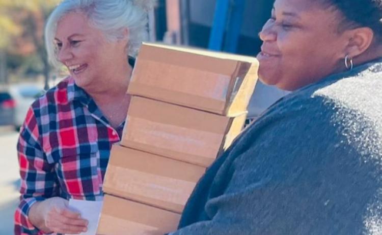 Volunteers Denise Smith, left, and Mariah Clark, right, pack a handful of the 20,000 meals prepared for malnourished peoples in Haiti on Nov. 27 in Lavonia.