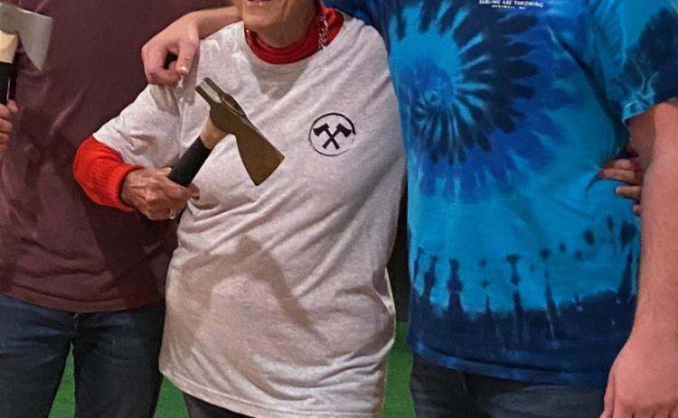 Maxine Davis (center) smiles after making her axe throwing debut at Sublime Axe Throwing.