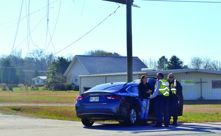 Officers talk to a driver after a wreck that took down a power line along Royston Highway,