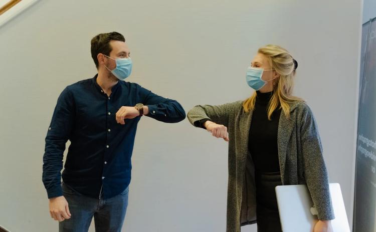 Man and woman practice COVID protocols. Photo credit: Maxime