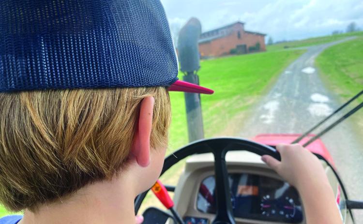 Nine-year-old Bayard, son of Eric and Connell NeSmith, takes us on a ride around the farm in our diesel tractor with an enclosed cab.