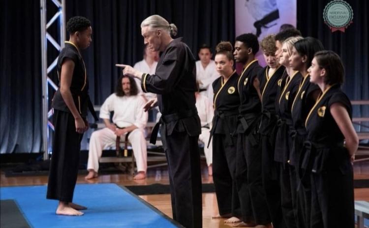 Hartwell Martial Arts instructor Chuck Cawthon, seated second person from left, appears as an extra in several scenes of the hit show “Cobra Kai.” Cawthorn is pictured above in one such scene featuring actor Thomas Ian Griffith (pointing).