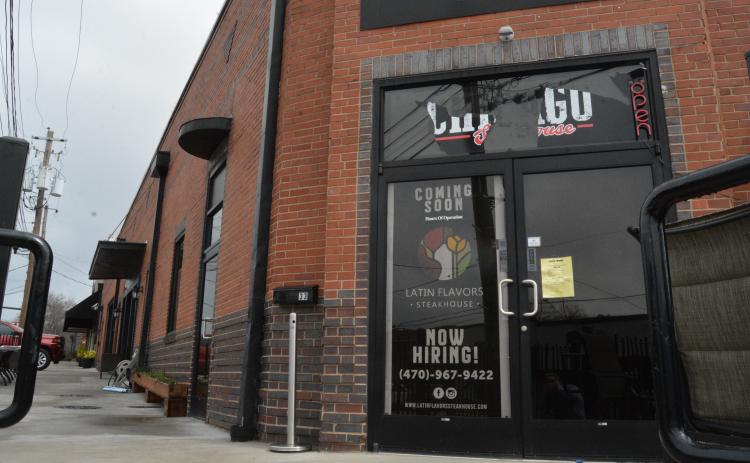 A sign indicating that Latin Flavors will be “coming soon” currently on the door at  33 Carolina Street.
