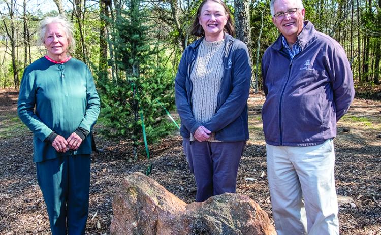 From left to right, Gretchen Torrence and Valerie and Bill Hinesley, stand near one of the new conifers and the heart-shaped rock along the conifer walk, The trio played large roles in the walk’s inception.