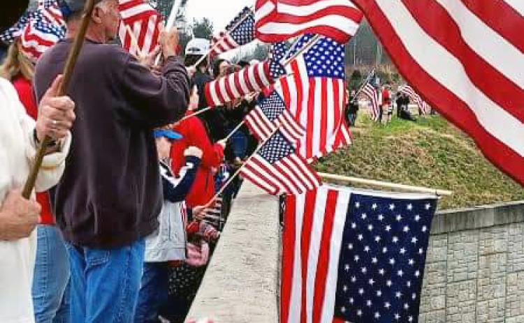 Hart County residents show their support for the convoy by waving Ole Glory.