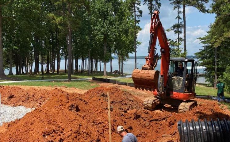 Sidney Skelton and crew members prepare the ground to install a new septic tank.