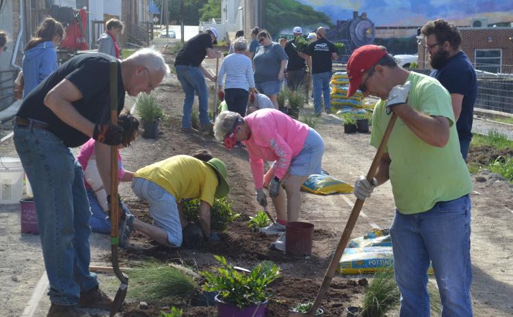 Volunteers help plant at the Railroad Street Park last week.