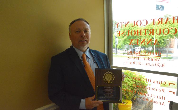 Hart County Clerk of Court Frankie Gray stands proudly with his award inside his office.