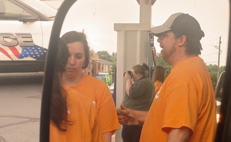 Dan Hunt/The Hartwell Sun Sideview mirror shot of three volunteers from The Pointe Church pumping gas and volunteering time and money in Lavonia on May 26.