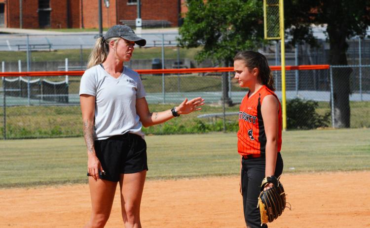 HCMS coach Kim Thomas gives EmmaKate White some pointers to improve her pitching.