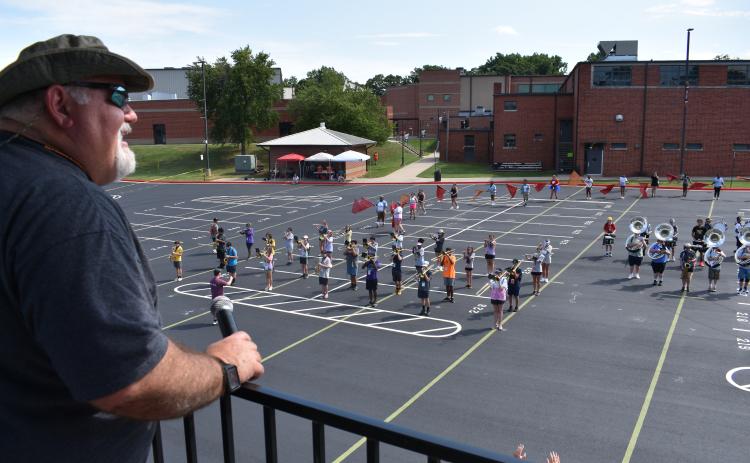 Hart County Band Director Alan Tolbert helps the Bulldog Band set drill from his tower in the high school parking lot. The show has been going on rather quickly this year, according to band leadership.