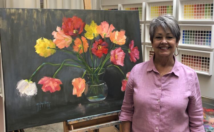 Debra Taylor, a.k.a. Taylor Dubeau, alongside one of her original paintings “Happy Explosion.” Taylor will have a full exhibit of original oil paintings on exhibit at the Hartwell Art Center beginning July 28.
