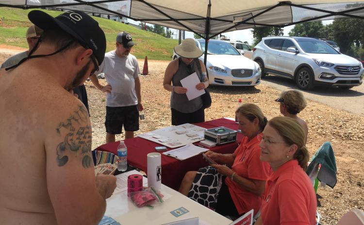 Photo of last year's Pontoon Poker Run with Hart Humane Society dealing a poker hand with an excited participant.