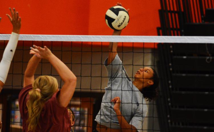 Cali Beebe goes up for a block against Alexis Walker.