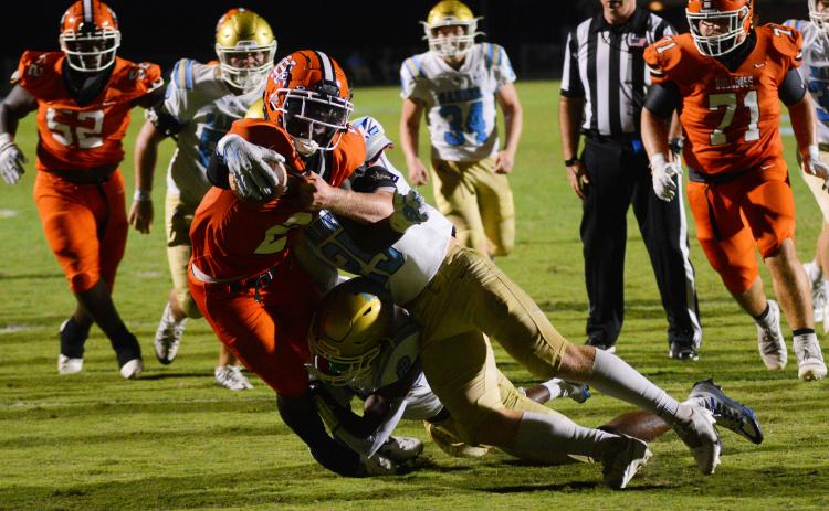 Paul Davis extends the ball over the goal line as multiple Daniel defenders try to bring him down.