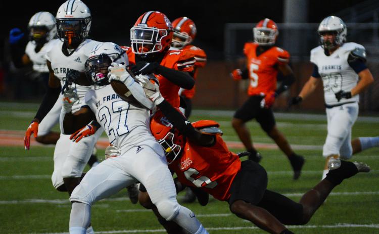 Keith Curry (11) and Jamir Rucker (6) bring down a St. Francis ball carrier in the win on Sept. 16.