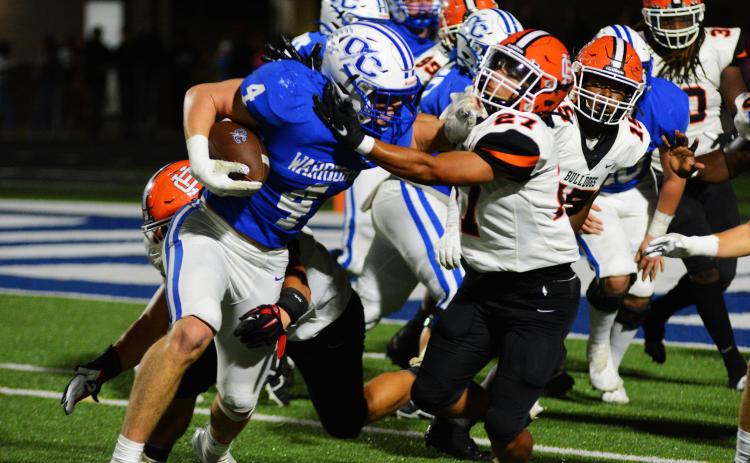 Na’tayvious Martin wrestles down Oconee County’s star player, Whit Weeks, on a goal line play on Oct. 7.