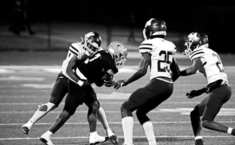 Junior running back Nori Moore attempts to shed the tackle of a Purple Hurricane defender in a tough region loss, 49-14.