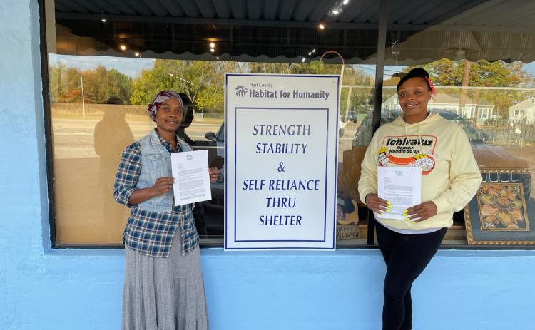 Hartwell residents Rebecca Durrett, left, and Brittany Harland, right, pose with their initial partner family agreement certificate with Hart County Habitat for Humanity building. Durrett and Harland were selected among several applicants for the newest home builds.