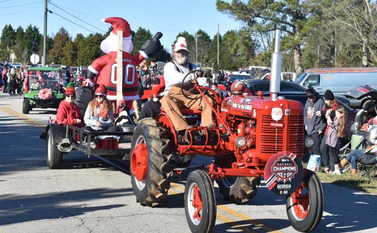 A gentleman takes his tractor along Montevideo Road Sunday at the annual Montevideo Christmas parade.