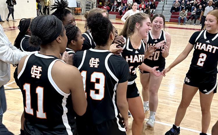 The Lady Dogs basketball team swarm their teammate Phillips in the aftermath of her high school scoring achievement.