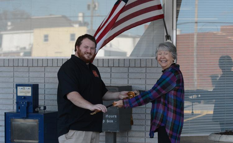 Joyce Kilpatrick (right) presents Hartwell resident Sam Simpson (left) with a Navy officer ceremonial sword that originally belonged to his late grandfather. Kilpatrick bought the sword at an auction before doing some investigating and returning it to its family.