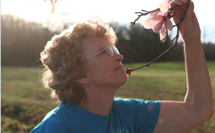 Gail Leopard checks on her blooming tulip tree at her home in the Airline community in Bowersville.