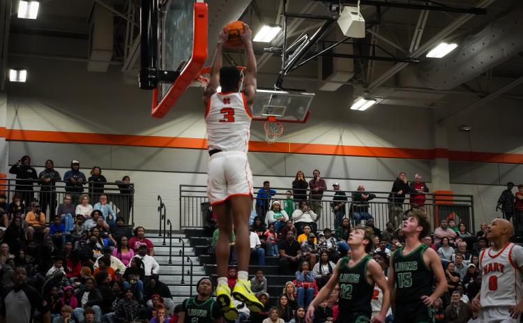 Senior Tahj Johnson rises above the rim to slam it home as he led the Dogs with 18 points in Hart County’s  win over the Franklin County Lions, 73-60 at home on senior night. (Photo by Lexie Wheless)