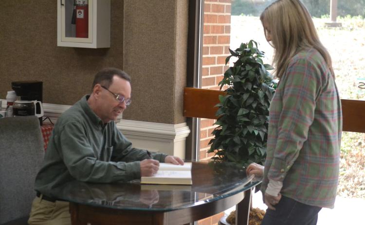 New York Times bestselling author John Cribb (left) signs a copy of his latest book, “The Rail Splitter” for Gwen Walters (right), of Hartwell, during a book signing and talk at the Hart County Library Jan. 26.