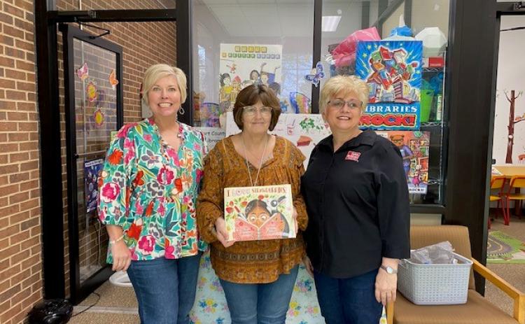 Hart County Farm Bureau Office Manager Tina Simmons, right, and  Hart EMC, Angie Brown, left, recently presented a copy of the children’s ag book “I Love Strawberries” to Pam Cole who accepts the book for the Hart County Public Library. The donation was made on behalf of the Georgia Foundation for Agriculture and Georgia EMC.