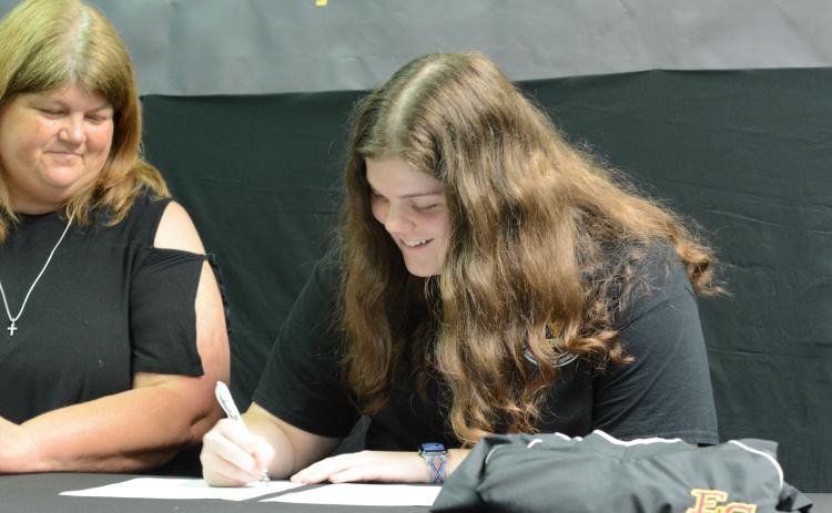 Senior Barnes Academy cheerleader Abbey Johnson (right) signs with Emmanuel College on Monday, May 15 to continue her academic and cheer career with the Lions. Her mom, Vickie Johnson, is pictured left.
