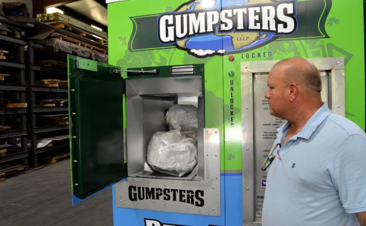 Gumpsters creator Kim Herron displays how his “pay as you throw” receptacle is used. The Hart County Board of Commissioners is the first municipality to incorporate the solid waste disposal option.