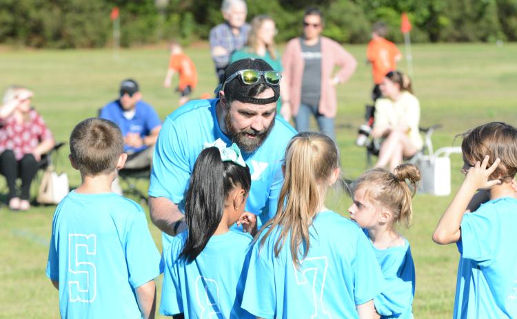 Tim Allgood coaches up his team before a game for the YMCA soccer league.